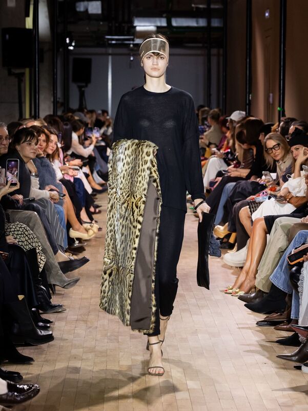 Модель в черной прозрачной блузе с леопардовым палантином, демонстрирует смелое сочетание текстур и силуэтов