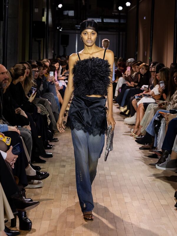 Черный топ с пушистым декором и широкие джинсы создают расслабленный, но стильный образ для вечернего выхода