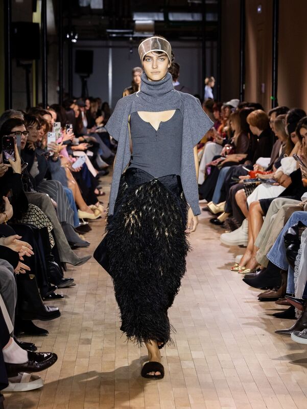 Образ с серым свитером и черной юбкой из перьев сочетает в себе элементы уюта и смелости, идеально для осеннего сезона