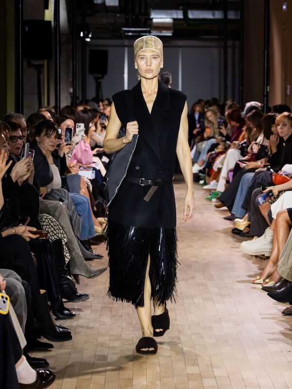 Модный черный жилет с бахромой, подчеркивающий фигуру, в сочетании с удобной обувью и стильной сумкой