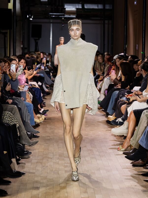 Минималистичное светлое платье с асимметричным кроем и текстурированными деталями, создающее воздушный образ