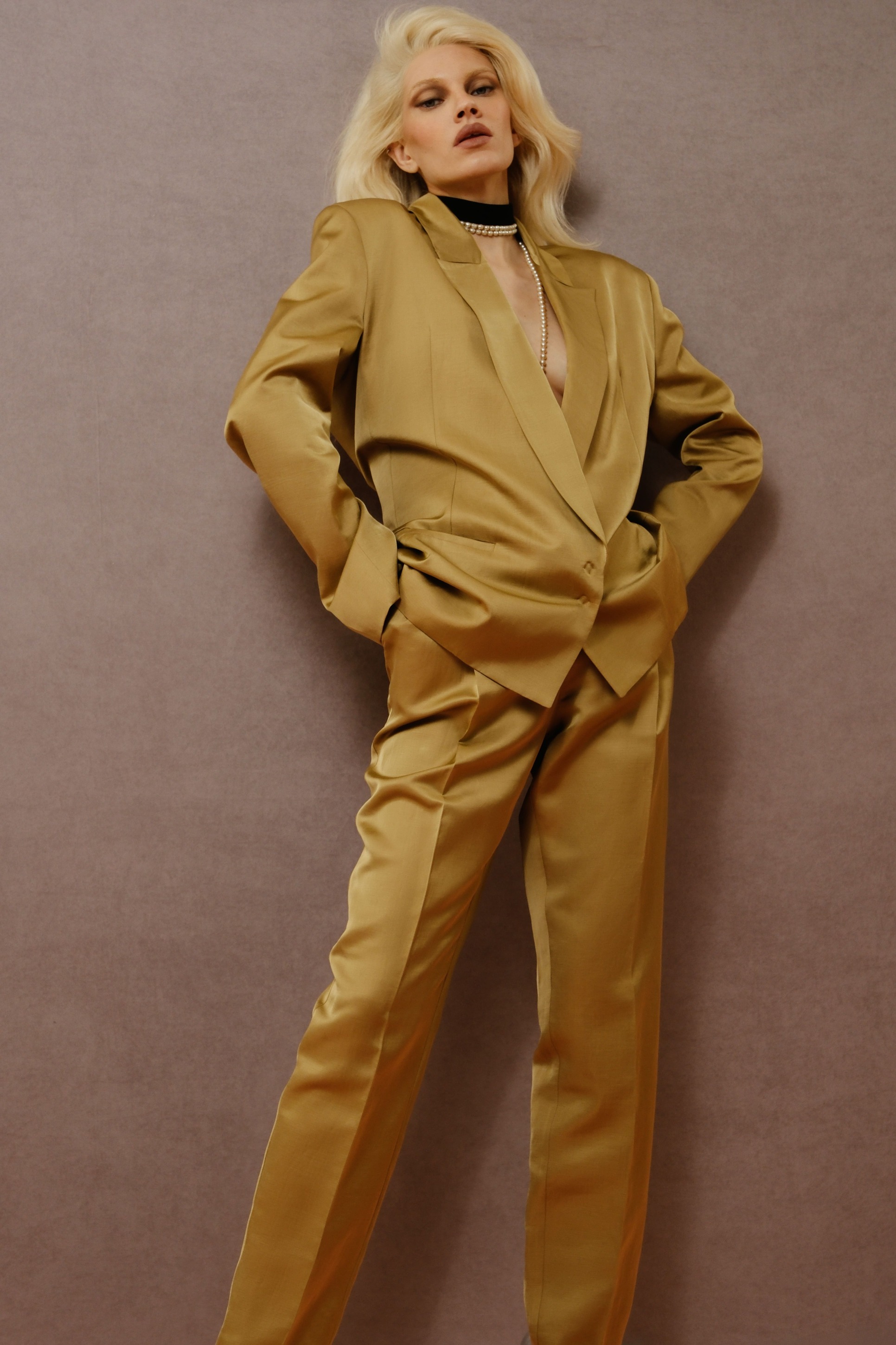Стильный золотистый костюм с глубоким вырезом и строгими линиями, создающий эффект уверенности и силы