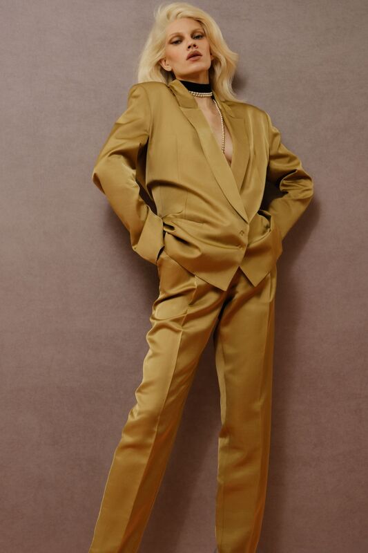 Стильный золотистый костюм с глубоким вырезом и строгими линиями, создающий эффект уверенности и силы