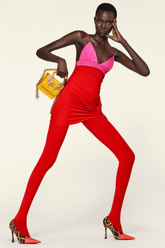 Обтягивающее красное платье с фуксиевыми акцентами и желтой сумочкой придает образу дерзость и яркость