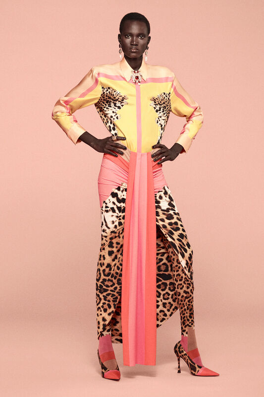 Яркая блуза с леопардовым принтом и розовой юбкой, создающей эффектный контраст на фоне нежно-розовой стены