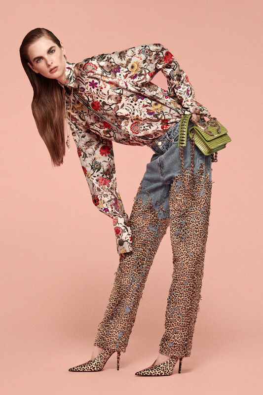 Блуза с ярким цветочным узором в сочетании с джинсами с леопардовым принтом, создающими смелый и экстравагантный образ