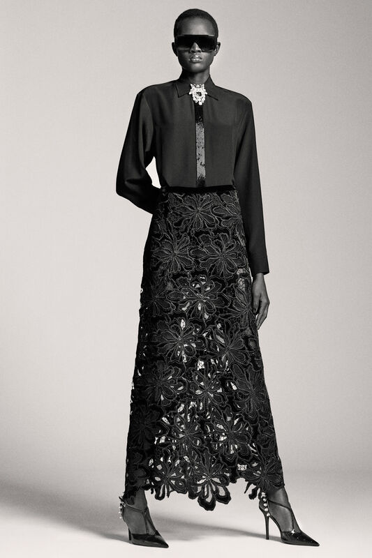 Элегантная черная блуза с блестящей отделкой и кружевной юбкой, создающей эффектный контраст с матовой текстурой