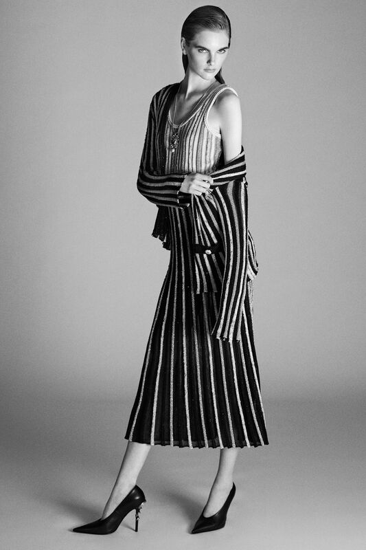 Стильный наряд с вертикальными полосами, состоящий из топа и юбки, акцентирующий внимание на фигуре и элегантности